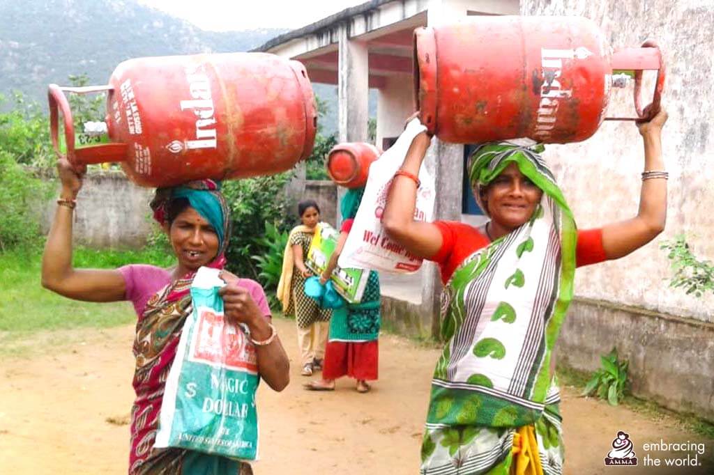 Indische Dorfbewohnerinnen mit Flüssiggas-Behältern
